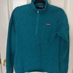 Patagonia women’s fleece quarter zip. Color is teal.